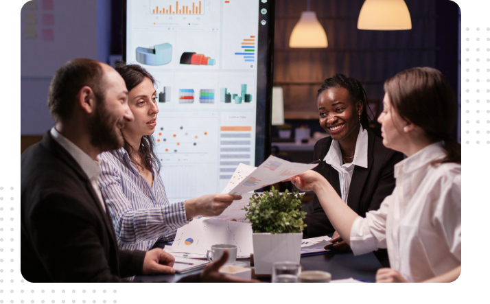 team-meeting-financial-analytics-dashboard-discussion Business team in a meeting discussing financial reports and analytics displayed on a large screen for strategic decision-making