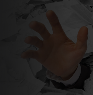 Hand reaching out from a pile of paperwork, representing the need for digital document automation to reduce manual processing.