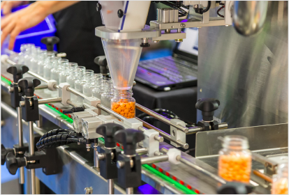 for-manufacturers Automated production line filling bottles with orange tablets, representing pharmaceutical or supplement manufacturing process.